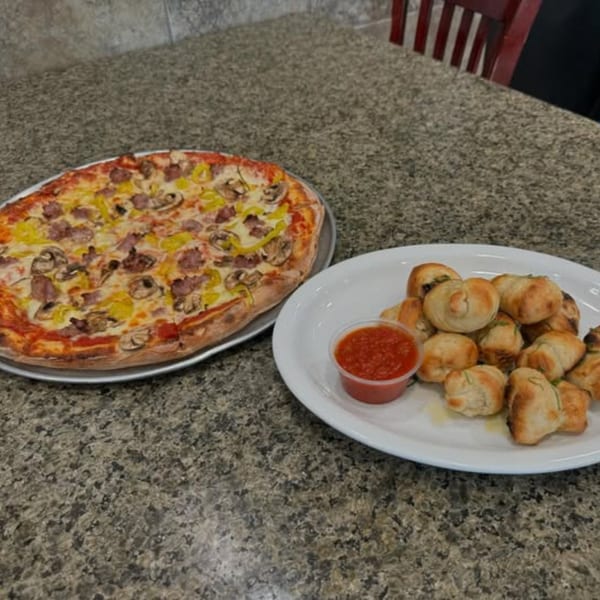 A 2 Brother's Pizza with sausage, mushrooms, and peppers, alongside a plate of garlic knots with marinara.